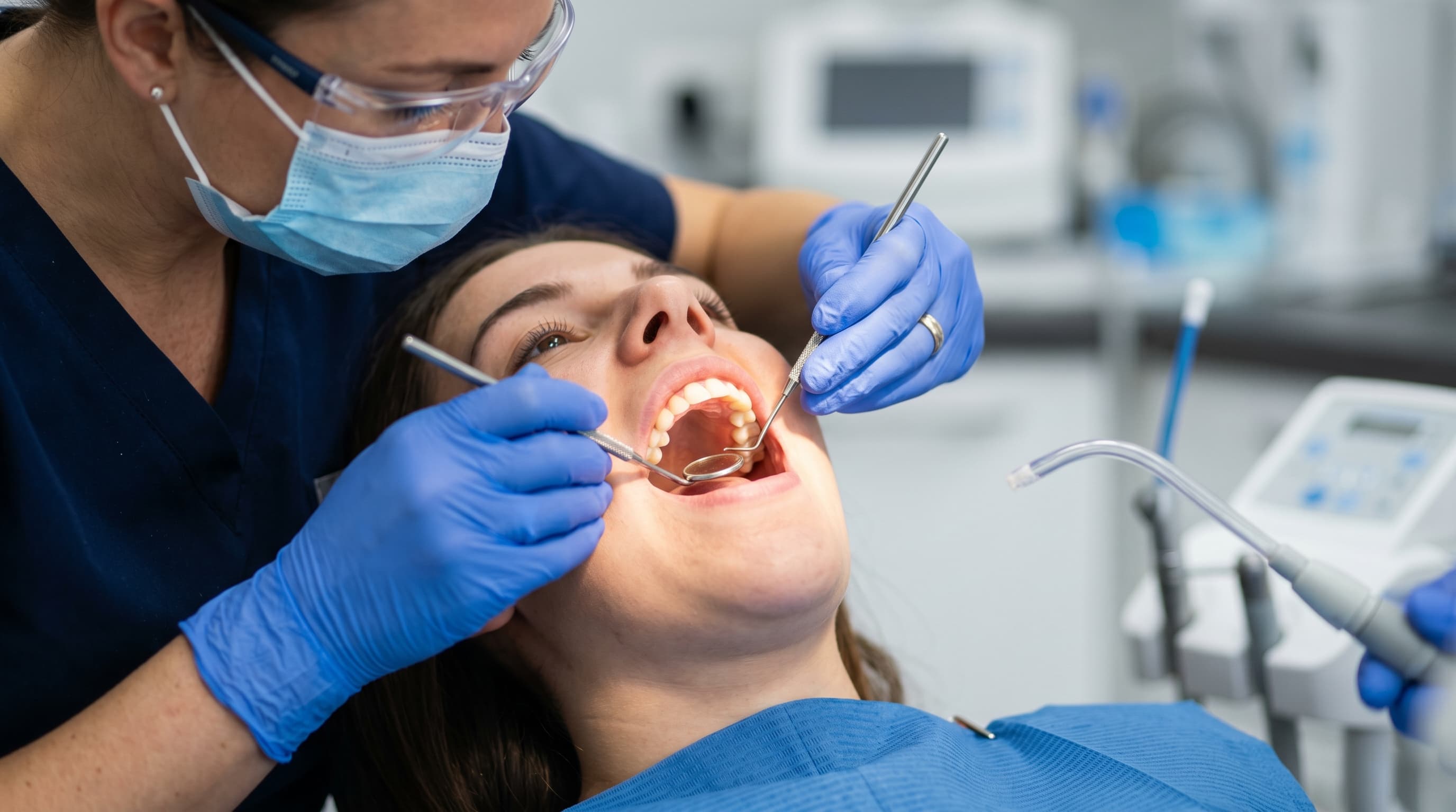 Dental hygienist performing a thorough exam and cleaning on a patient